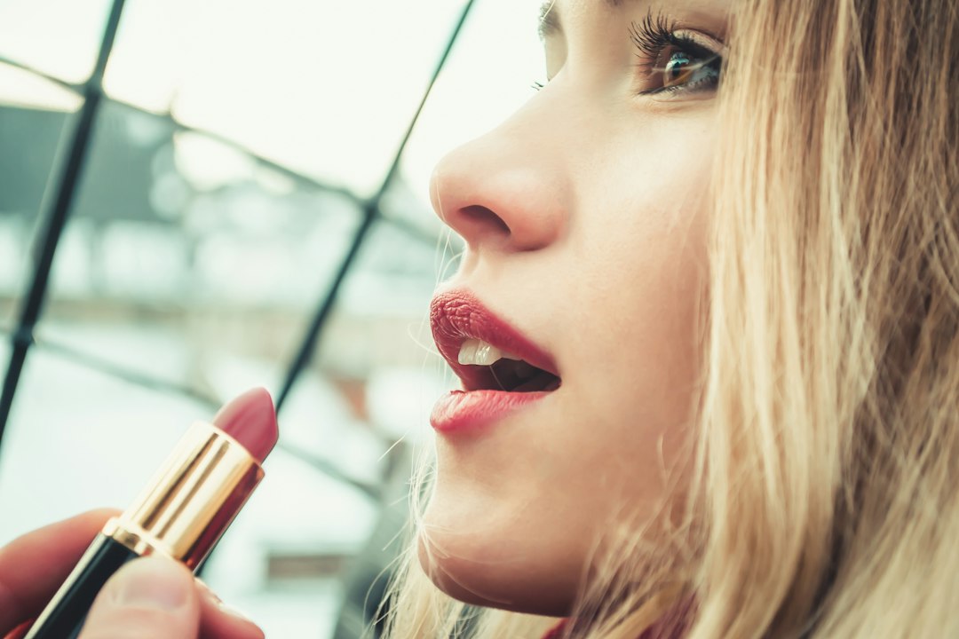 Woman applying a bold lipstick shade for a statement lip look