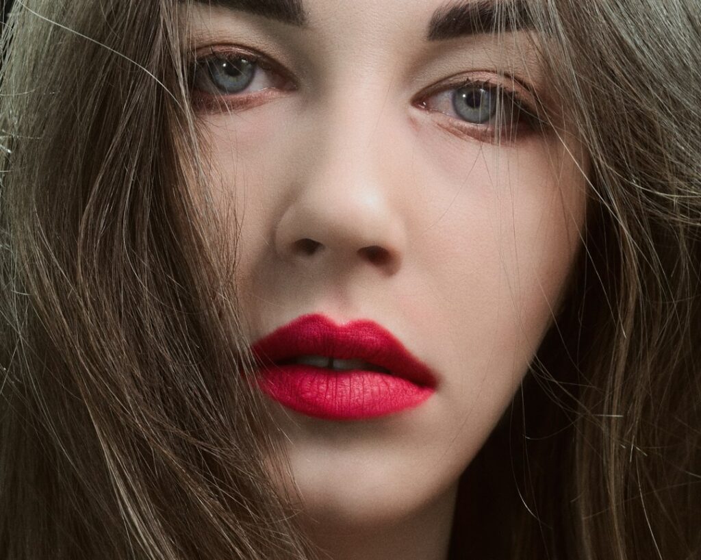 Close-up beauty portrait featuring bold magenta lipstick