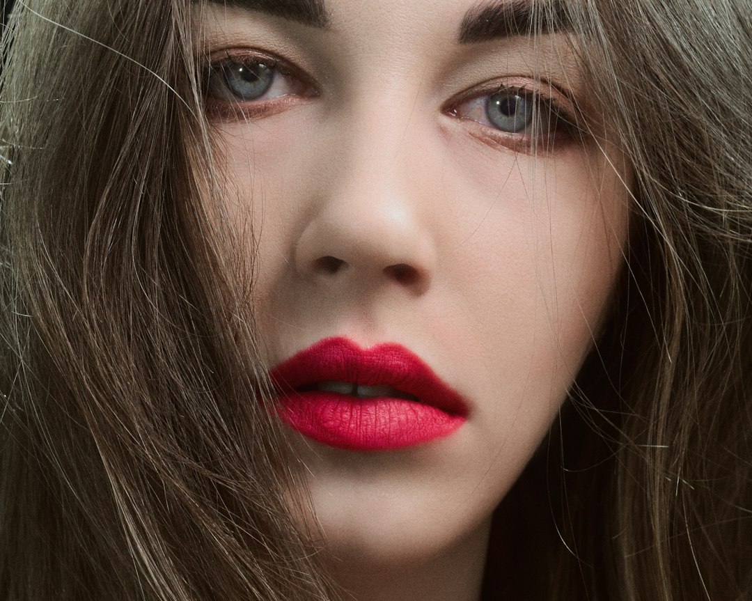 Close-up beauty portrait featuring bold magenta lipstick