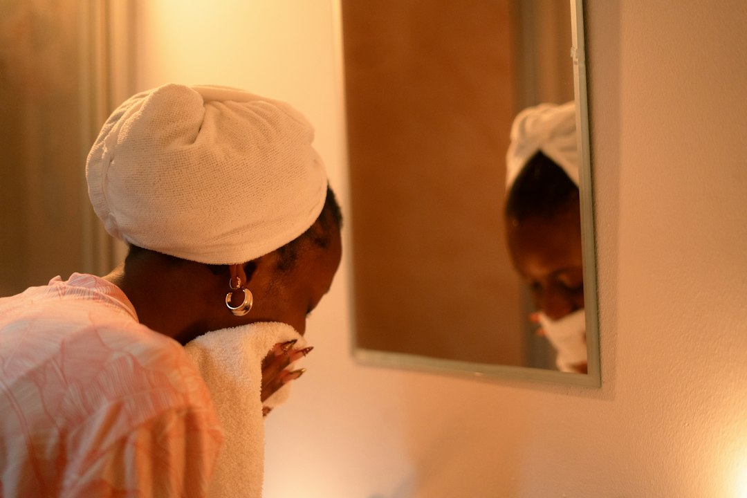 Woman gently patting her face dry after cleansing