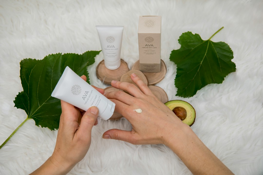 Hands holding a cream tube during a daily moisturizing routine
