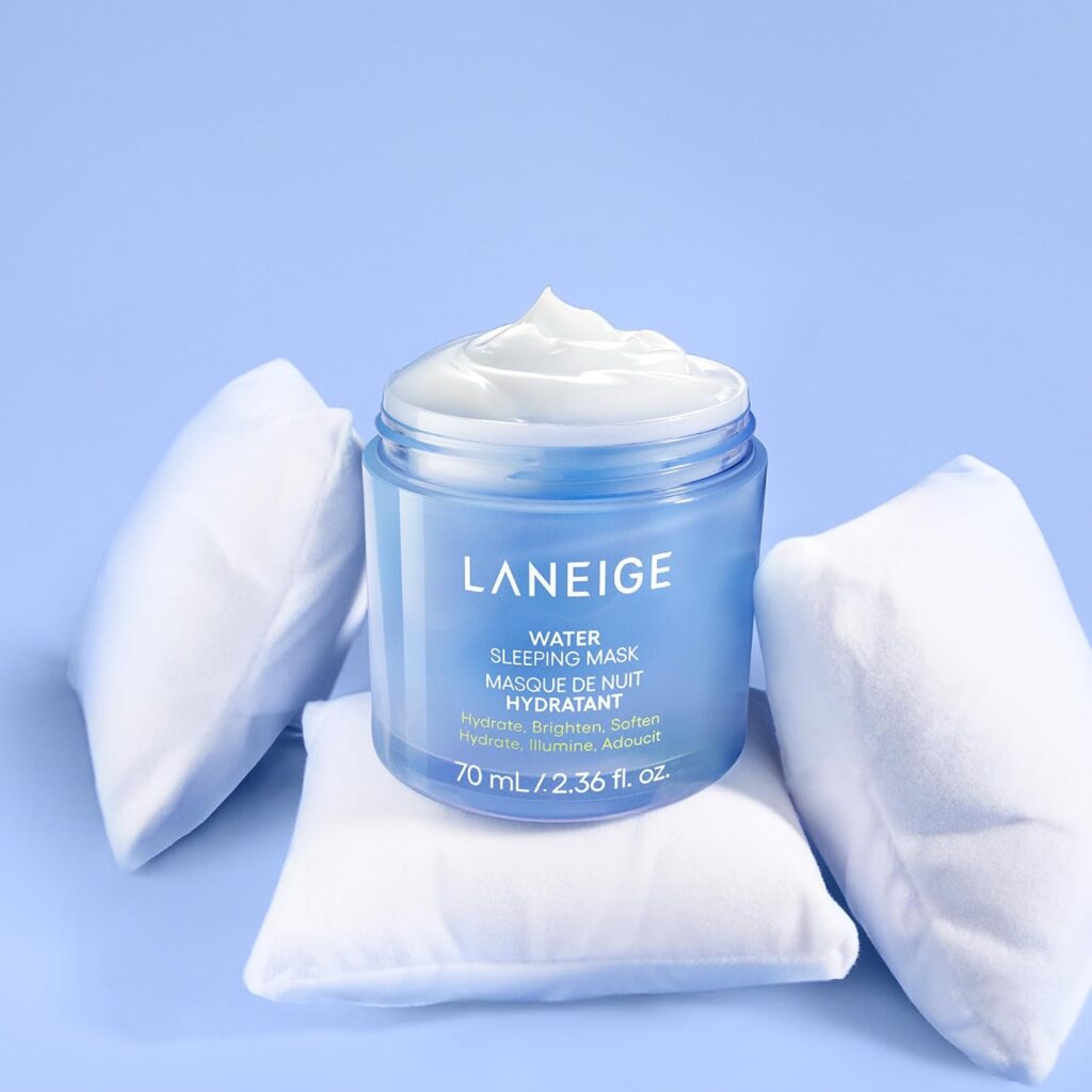 Open blue LANEIGE Water Sleeping Mask jar resting on miniature white pillows against a blue background