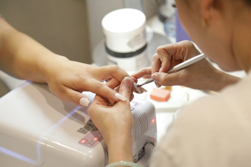 Manicurist applying nail polish during a professional manicure